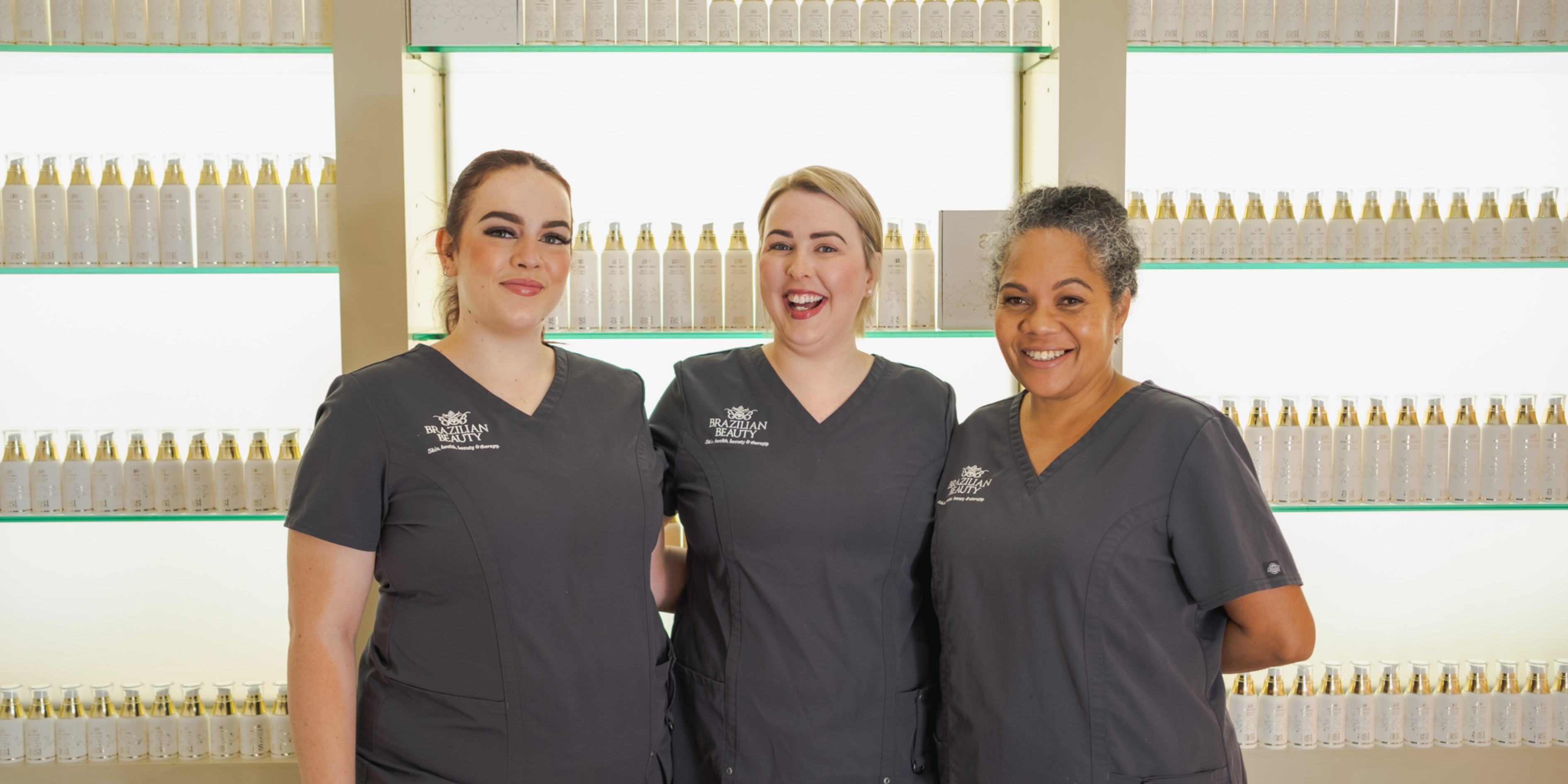 3 women working at Brazilian Beauty smiling together - lash experts